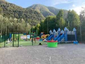 ポルレッツァにあるSunwaychalets Lago di Luganoの山を背景に遊び場のある公園