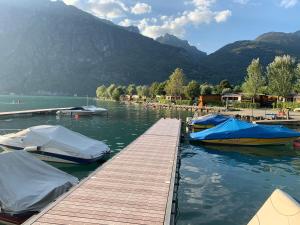 Zwei Boote sind an einem Dock auf einem See angedockt. in der Unterkunft Sunwaychalets Lago di Lugano in Porlezza