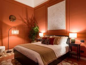 ein Schlafzimmer mit einem großen Bett mit orangefarbenen Wänden in der Unterkunft Kondo Maisons in Catania