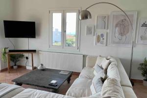 a living room with a white couch and a table at Villa Oinoni in Egina