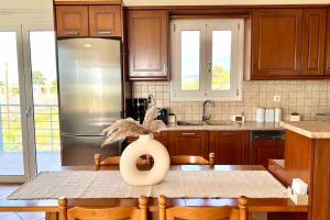 a kitchen with a refrigerator and a table with chairs at Villa Oinoni in Egina +28 photos