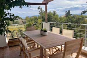 a wooden table and chairs on a balcony at Villa Oinoni in Egina
