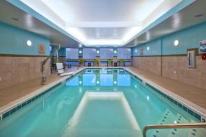本頓港的住宿－SpringHill Suites by Marriott St. Joseph Benton Harbor，大楼内的一个蓝色海水游泳池