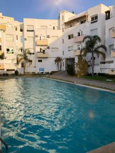 a swimming pool in front of a building at Fantastique Appartement avec piscine sur la plage M2 in Tangier