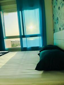 um quarto com uma cama grande e uma janela em Fantastique Appartement avec piscine sur la plage M2 em Tânger