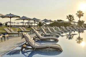 a row of lounge chairs and umbrellas at a resort at Iberostar Selection Diar El Andalous in Port El Kantaoui
