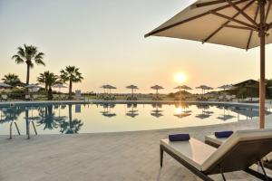 a swimming pool with a table and an umbrella at Iberostar Selection Diar El Andalous in Port El Kantaoui