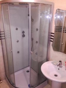 a shower with a glass door next to a sink at Fantastique Appartement avec piscine sur la plage M2 in Tangier