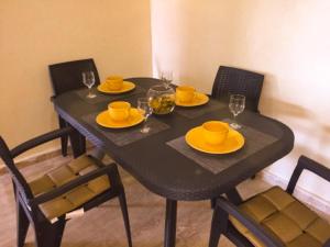uma mesa preta com placas amarelas e óculos em Fantastique Appartement avec piscine sur la plage M2 em Tânger