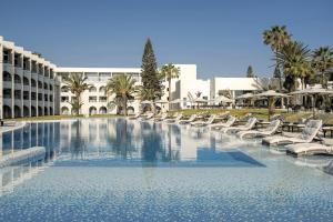 a large swimming pool with lounge chairs and a building at Iberostar Selection Diar El Andalous in Port El Kantaoui