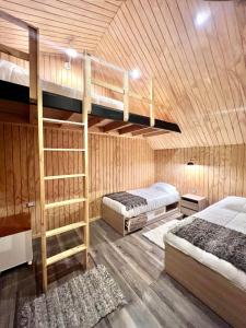 two bunk beds in a room with wooden walls at AncudLodge in Ancud