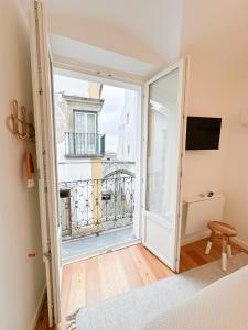 a bedroom with a door open to a balcony at Largo Inn Suites Evora in Évora