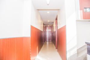 un pasillo con paredes de color naranja y blanco y una puerta en OYO Hotel Executive Inn en Agartala