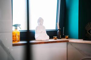 a statue of a buddha sitting on a window sill at Luxusapartment in Backnang mit Wellness in Backnang +19 photos