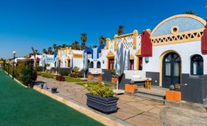 una fila de casas blancas con palmeras en el fondo en Sonesta Nouba Hotel Aswan en Asuán