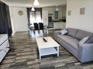 a living room with a couch and a table at Maison de vacances récente in La Bétaudière