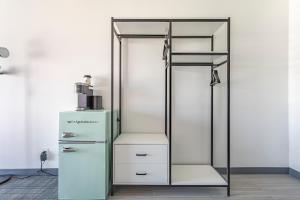 a glass and metal closet with a white refrigerator at Hotel Koxie in Los Angeles