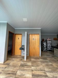 an empty room with two doors and a tile floor at Espaço de lazer 3E in Dourados
