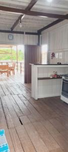 cocina con armarios blancos y suelo de madera en Casa de Praia - Ajuruteua Pará, en Ajuruteua