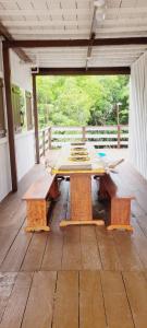 una mesa de madera y bancos en un patio en Casa de Praia - Ajuruteua Pará, en Ajuruteua