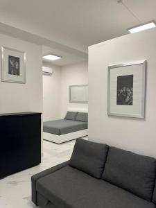 un soggiorno con divano e 2 letti di Cernusco luxury Milanese apartment a Cernusco sul Naviglio