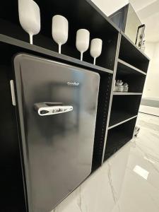 una nevera de acero inoxidable en una cocina con estanterías en Cernusco luxury Milanese apartment, en Cernusco sul Naviglio