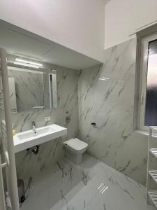 Baño blanco con lavabo y aseo en Cernusco luxury Milanese apartment, en Cernusco sul Naviglio