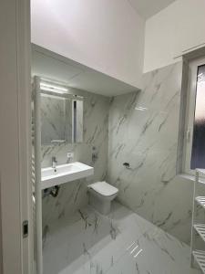 Baño blanco con lavabo y aseo en Cernusco luxury Milanese apartment, en Cernusco sul Naviglio