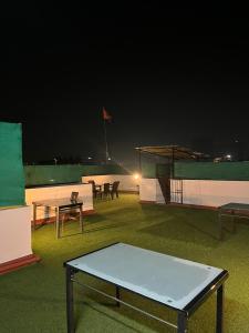 eine Gruppe von Tischen und Stühlen auf einem Feld in der Nacht in der Unterkunft Fully Furnished Luxurious Terrace apartment in Pune