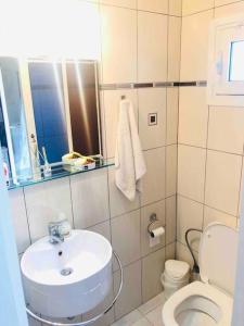 a white bathroom with a sink and a toilet at Sea House Kaminia in Kamínia +31 photos