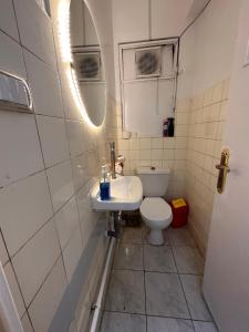 een badkamer met een toilet, een wastafel en een spiegel bij Quiet studio in downtown in Caïro