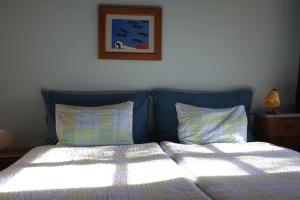 een bed met twee kussens en een foto aan de muur bij private room with own bathroom at Podere Noceto in Grotti