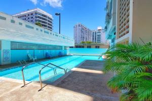 una piscina en medio de un edificio en Playa Escondida Oceanview Pool Parking 1BDR, en San Juan