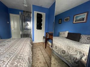 - une chambre avec un lit et un mur bleu dans l'établissement Livadia House at St Leonards on Sea, à St. Leonards