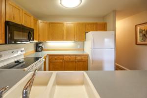 a kitchen with a white refrigerator and wooden cabinets at Meadow Lake Resort & Condos in Columbia Falls