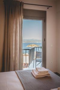 a bedroom with a bed and a view of the ocean at Votsalo Tolo in Tolo