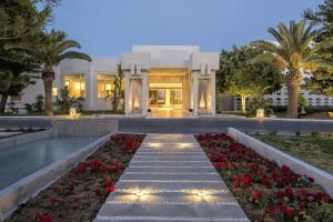a home with a pathway leading to a building with flowers at Iberostar Selection Diar El Andalous in Port El Kantaoui