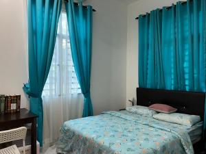 um quarto com uma cama com cortinas azuis e uma janela em Damai Kangar Homestay em Kangar