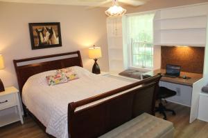 a bedroom with a bed and a desk with a laptop at Alpine Oasis - House in the Adirondacks close to Lakes, Golf, Skiing and so much more! 