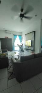 een woonkamer met een bank en een flatscreen-tv bij Damai Kangar Homestay in Kangar