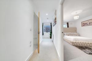 Dormitorio blanco con cama y pasillo en Spacious Modern 1 Bed Apartment London Catford Lewisham - Perfect for Long Stays en Londres