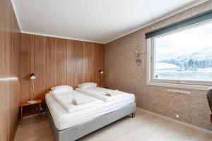 een slaapkamer met een bed en een groot raam bij Stunning view apartment in Ålesund with free parking in Ålesund
