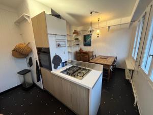 a kitchen with a stove top oven next to a table at Appartement château Angers 147 m² in Angers