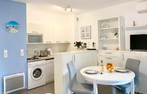 een keuken met een witte tafel en stoelen en een wastafel bij Inter Superb Studio Piscine 5 min gare in Menton