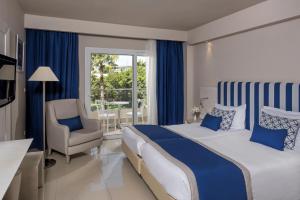 een slaapkamer met een bed, een stoel en een raam bij Iberostar Selection Diar El Andalous in Port El Kantaoui