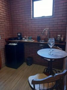 una mesa con una copa de vino encima en Vivendas Canaã, en Espera Feliz