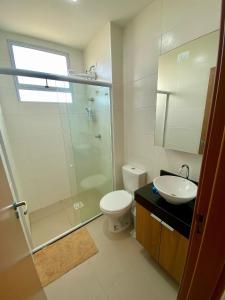 a bathroom with a shower and a toilet and a sink at Apartamento em Ponta de Campina in Cabedelo