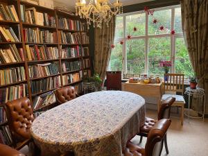 a library with a table and chairs and a large window at Livadia House at St Leonards on Sea in St. Leonards