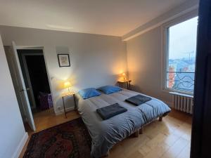 a bedroom with a bed and a large window at Appartement château Angers 147 m² in Angers