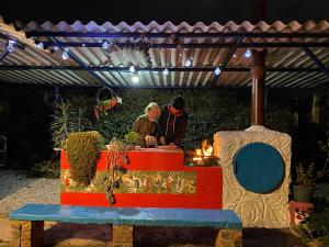 dos personas de pie en una mesa en un jardín por la noche en VILLA CONCHITA, en Duitama